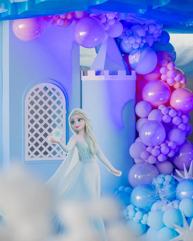 Castillo con Elsa y globos en tonos azul y lila