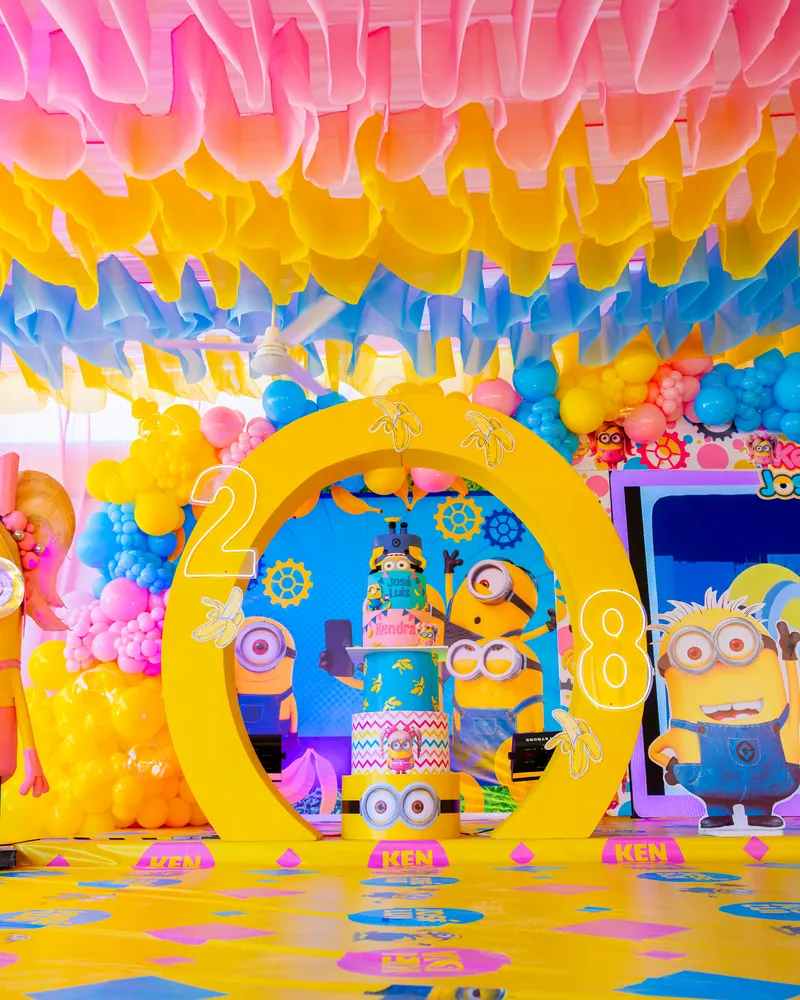 Arco amarillo con globos y el pastel de Minions