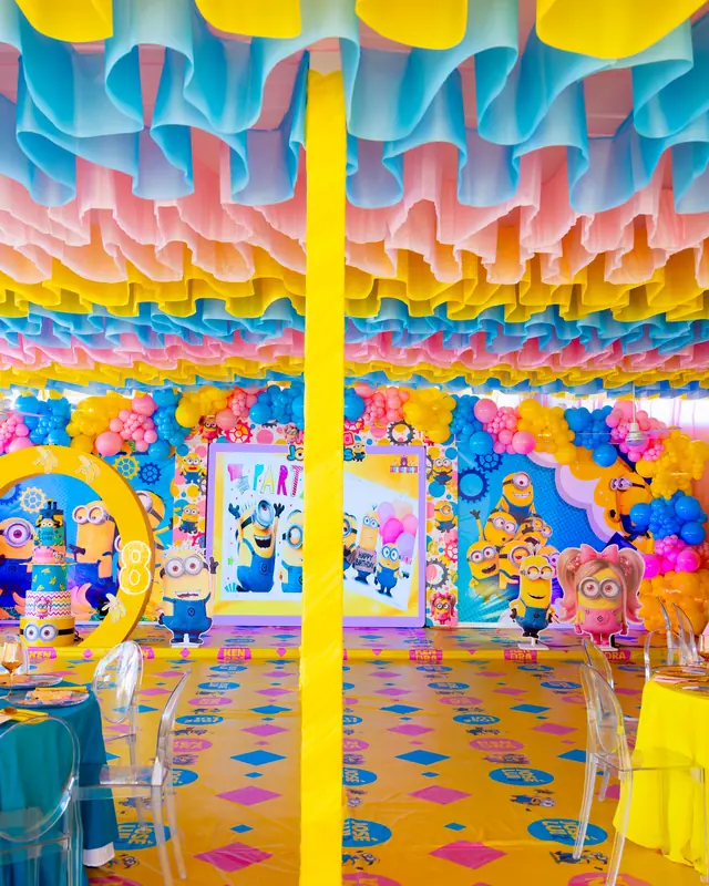Salón transformado con techo de papel de colores y escenografía de Minions